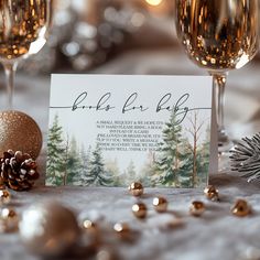 a table topped with wine glasses next to a christmas ornament and a card