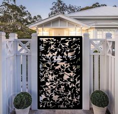 a black and white door is in front of a house with two potted plants