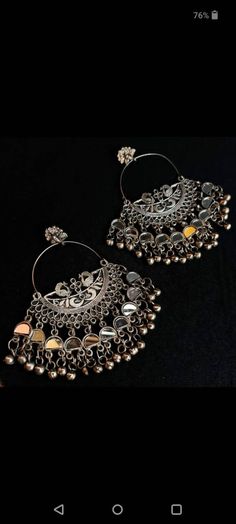 Dramatising the classic hoop style of earrings, is this gorgeous pair of earrings that boasts of striking detail with ghungroo hangings.. Glamorous yet effortless, these hoops are real keepers for souls who are looking for a classic yet versatile piece of jewelry. The kind of jewelry that adds oomph to your casual wear and also matches the edge of your occasion special Indian Wear. Oxidized Finish Chandbali Hoop Earrings, Oxidized Finish Earrings For Party And Festivals, Festive Metal Hoop Earrings In Temple Jewelry Style, Silver Chandelier Earrings With Oxidized Finish For Festive Occasions, Metal Chandbalis In Temple Jewelry Style, Festival Party Earrings With Oxidized Finish, Festival Oxidized Danglers, Festive Metal Hoop Earrings, Festive Silver Nickel-free Chandelier Earrings