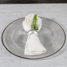 a glass plate with a napkin on it and a green plant sticking out of the top