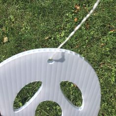 a frisbee that is on the ground in the grass with it's string attached