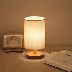 a lamp that is sitting on a table next to a book and an open book