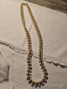 This necklace has double pearl strands with gold scroll pattern between. This has a simple gold clasp.  The Napier Company got its start in North Attleboro, Massachusetts 1878, under the name of The E. A. Bliss Co., manufacturing gilt men's watch chains. The company ceased operations in 1999 and at that time considered the oldest fashion jewelry house in America.  No issues.  12" Traditional Gold Pearl Necklace For Formal Occasions, Gold Double Strand Pearl Necklace, Gold Beaded Pearl Necklace For Formal Occasions, Gold Single Strand Pearl Necklace For Wedding, Classic Gold Pearl Necklace With Gold Beads, Gold Double Strand Pearl Necklace For Formal Occasions, Formal Gold Double Strand Pearl Necklace, Gold Pearl Costume Jewelry Necklace, Antique Gold Pearl Chain Necklace