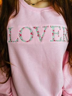 Using a light mint green, baby blue, hot pink, soft pink, and yellow threads, this sweet flowers design spells LOVER. A perfect Valentine's Day sweatshirt! Sizing: -Unisex fit. Please check the guidelines for measurements. Sweatshirt is a pink color and is 50% cotton / 50% polyester Care instructions: Wash inside out in cold water, tumble dry low. Do not bleach. Colors may appear slightly different on screen as it does in person due to the different display ranges. I try my best to correctly show each item, but know that there might be slight variations. There are no returns, but if there is an issue with your order, please message me! Thank you for shopping my small business! Feel free to reach out with any questions. Casual Pink Sweatshirt With Machine Embroidery, Cute Pink Tops With Custom Embroidery, Cute Pink Top With Custom Embroidery, Pink Cotton Sweatshirt With Floral Embroidery, Pink Cotton Tops With Floral Applique, Pink Cotton Sweatshirt With Machine Embroidery, Spring Pink Tops With Letter Embroidery, Pink Long Sleeve Sweatshirt With Machine Embroidery, Pink Crew Neck Sweatshirt With Machine Embroidery