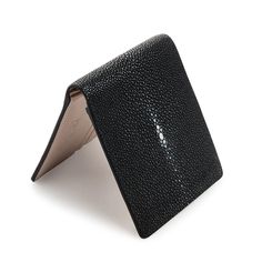 Genuine White Pearl Black Polished Stingray Leather Wallet  Features genuine stingray leather for exterior and cowhide leather for interior;  Bi-fold design;  Size closed: 4 ½” x 3 6/8” (approx 11.5 cm x 9.5 cm);  Award-winning product in the handicraft category (Thailand);  2 clear ID slots, 10 credit card slots, 2 bill compartments;  Handmade product.   Sleek, compact, and rugged, this White Pearl Black Polished Stingray Leather Wallet is an ideal money accessory. It provides plenty of slots t Black Textured Leather Wallet For Business, Black Leather Wallet With Crocodile Pattern, Luxury Leather Wallets With Silver-tone Hardware, Luxury Leather Wallet With Silver-tone Logo, Black Textured Leather Rectangular Wallet, Black Polish, Stingray, White Pearl, Cowhide Leather