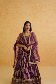 Stunning purple georgette lehenga featuring an intricately embroidered blouse adorned with crystals, stones, and cutdana details. Elegant Purple Set With Zari Work, Elegant Purple Sets With Zari Work, Elegant Purple Anarkali Set With Zari Work, Designer Purple Salwar Kameez With Resham Embroidery, Elegant Unstitched Purple Anarkali Set, Elegant Purple Salwar Kameez With Traditional Drape, Purple Salwar Kameez With Dabka Work For Reception, Elegant Purple Anarkali Set With Sheer Dupatta, Purple Salwar Kameez With Resham Embroidery For Reception