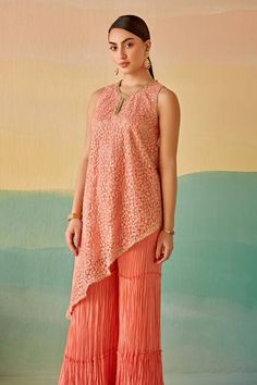 Peach asymmetric tunic with thread and mirror embroidery. Paired with a sharara. - Aza Fashions Designer Sleeveless Kurta For Spring, Elegant Sleeveless Kurta For Spring, Elegant Sleeveless Designer Kurta, Elegant Sleeveless Summer Kurta, Elegant Sleeveless Party Kurta, Summer Sleeveless Anarkali Kurta, Sleeveless Kurta For Summer Weddings, Sleeveless Anarkali Kurta For Summer, Sleeveless Kurta For Eid Reception