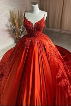 a red ball gown on display in front of a mannequin