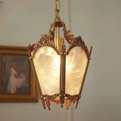 a chandelier hanging from the ceiling in a room with pictures on the wall