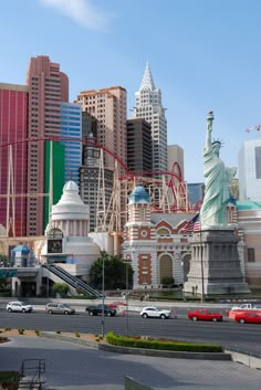 the statue of liberty stands in front of many tall buildings