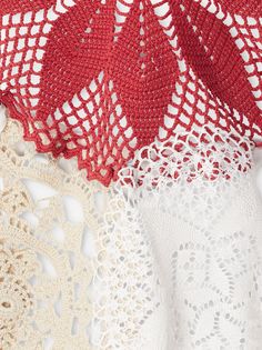 three crocheted doily on top of each other, one white and one red