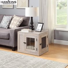 a living room with a gray couch and a dog crate on the coffee table in front of it