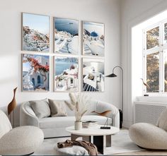 a living room filled with white furniture and pictures on the wall above it's windows