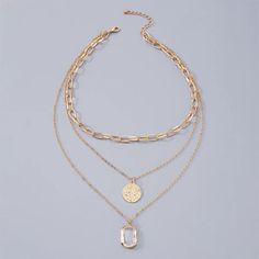 Express your love for layers with 3-in-1 Star Crystal Coin Necklace. Whether you're a fan of gold or silver, this necklace is a trendy piece that's perfect for today's fashion-forward crowd. Constructed from a sturdy steel alloy and coated with an elegant 18 karat gold plating, this necklace is designed to last. The first chain is a chic paperclip choker, the second boasts a disc/coin pendant featuring a charming star design, while the third is adorned with a clear, faceted crystal gemstone that Trendy Multi-strand Charm Necklaces, Trendy Alloy Layered Necklace With Chain, Trendy Alloy Layered Chain Necklace, Trendy Metal Layered Necklace With Clavicle Chain, Trendy Gold Plated Delicate Chain Layered Necklace, Trendy Gold Plated Layered Necklace With Adjustable Chain, Layered Minimalist Metal Jewelry, Trendy Alloy Double Chain Jewelry, Trendy Layered Metal Chain Necklace