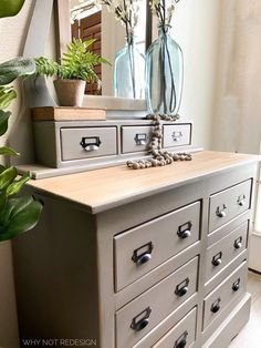 a dresser with drawers and vases sitting on it's side in front of a mirror