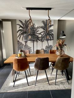 a dining room table with four chairs and an art work on the wall behind it