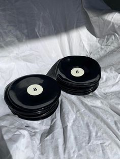 two black bowls with white numbers on them sitting on top of a sheeted surface