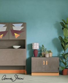 a living room with blue walls and green plants in pots on top of the shelves