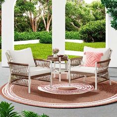 two chairs and a table sitting on top of a rug