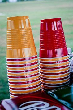 several orange and red cups sitting on top of a table next to each other in the grass