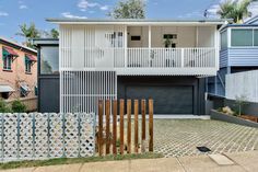 a white house with two balconies on the second floor and an attached deck