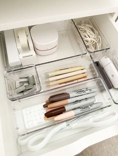 the drawers are organized with pens, pencils and other office supplies in clear plastic containers