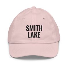 Crafted for comfort and designed for those who love Smith Lake, this embroidered youth-sized hat is sure to become an essential to all your outdoor adventures. Featuring an adjustable strap, it offers a great fit, comfort, and a stylish design. • 100% bio-washed chino cotton twill• Head circumference: 21″–21.57″ (53.3 cm–54.8 cm)• Unstructured, 6-panel, low-profile• Adjustable self-fabric hideaway strap closure• Brass-toned tri-glide buckle• Blank product sourced from Bangladesh Tag us on Instag Outdoor Letter Print Hat, Adjustable Sports Dad Hat With Embroidered Logo, Cotton Baseball Cap For Hiking, Adjustable Hats With Embroidered Logo And Curved Brim, Letter Print Cap For Outdoor Activities, Casual Flat Bill Baseball Cap For Camping, Adjustable Dad Hat With Embroidered Logo For Outdoor, Adjustable Sports Hats With Embroidered Logo, Casual Baseball Cap With Flat Bill For Adventure