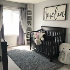 a baby's room with a crib, teddy bear and bookshelf