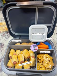 an open lunch box filled with different types of food and labels on the inside of it