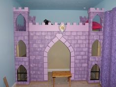 a purple castle bed in a child's bedroom with a table and chair next to it