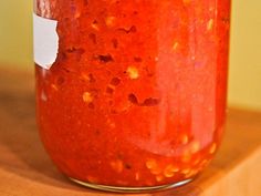 a jar filled with red liquid sitting on top of a wooden table