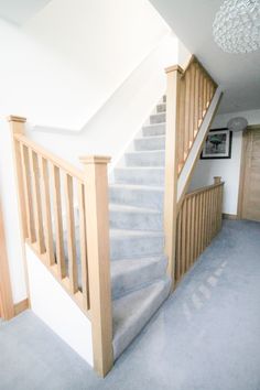 the stairs in this house are made of wood and have white carpeting on them