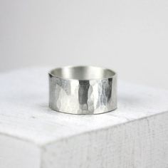 This simple, striking wide band ring is forged from recycled sterling silver and given a smooth interior for comfort while the exterior is hammered and given a bright finish. This is a versatile ring with a lovely organic feel. It looks great on both men and women, dressy or casual. The ring makes a simple minimalist statement with an added organic touch of hand hammered silver.Made to order in ring sizes 5.5 to 14.0. The band is 3/8” wide (10mm). Because wide bands require extra room to fit you Jewelry Template, Wide Band Ring, Custom Wedding Rings, Simple Ring, Jewelry Simple, Wide Band Rings, Ring Minimalist, Hammered Silver, Rings Simple