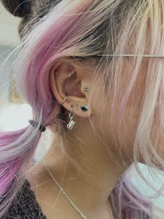 a woman with pink hair and piercings on her ear