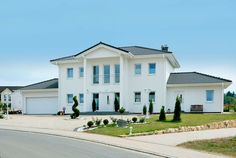 a large white house sitting on the side of a road