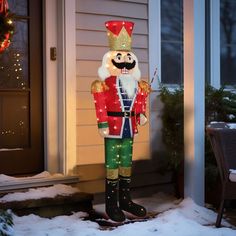 an inflatable christmas nutcracker is standing on the front porch with its lights on