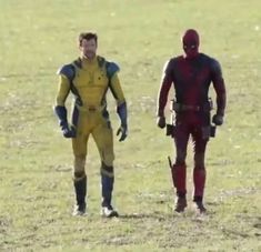 two men dressed in yellow and red standing next to each other on a grass field