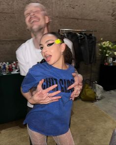 a man and woman are dancing together in front of a camera with their arms around each other