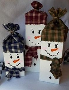 three snowmen are standing next to each other with plaid hats and scarves on