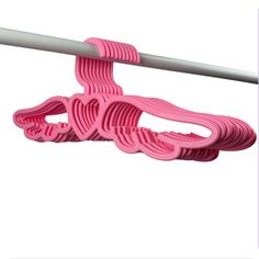 pink clothes hangers are attached to a white pole