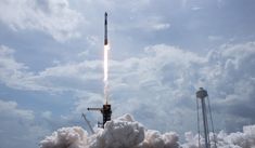 a rocket launching into the sky with clouds in the background