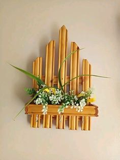 a bamboo wall decoration with flowers and greenery