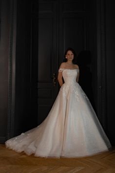 a woman in a white wedding dress posing for the camera with her hands on her hips