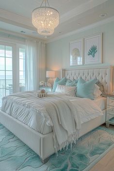 a large white bed sitting in a bedroom next to a window