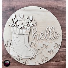 a wooden plaque with the word hello written on it, and a boot with flowers