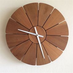 a wooden clock with white hands on a wall