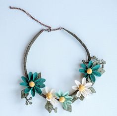 a necklace with flowers and leaves on it