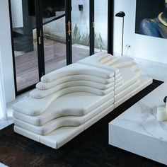 a living room filled with white couches and tables