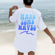 Make Some Waves t-shirt featuring retro gradient font. This trendy tee is perfect for a beachy vacation! Size up for an oversized look. This classic unisex jersey short sleeve tee fits like a well-loved favorite. Soft cotton and quality print make users fall in love with it over and over again. These t-shirts have-ribbed knit collars to bolster shaping. The shoulders have taping for better fit over time. Dual side seams hold the garment's shape for longer. - 100% Airlume combed and ringspun cott Blue Slogan T-shirt For Summer, White Vsco T-shirt With Text Print, Casual Beach T-shirt With Graphic Design, Beach Graphic Crew Neck T-shirt, Beach Graphic Cotton Tops, Beach Cotton Tops With Graphic Design, Cotton Beach Tops With Graphic Design, Summer Gradient Color Short Sleeve Top, Beach Graphic Tee With Graphic Design