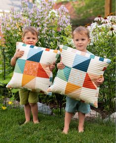 two young boys are holding pillows made out of quilts in their hands and smiling at the camera